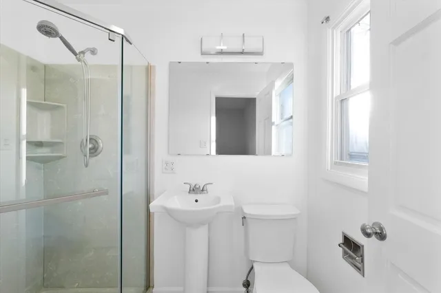 a bathroom with a sink a toilet and shower