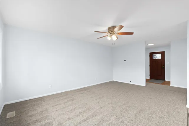 an empty room with closet and a chandelier fan