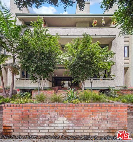 a front view of a house with a yard and potted plants
