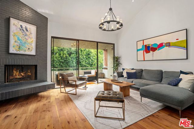 a living room with furniture large window and a fireplace