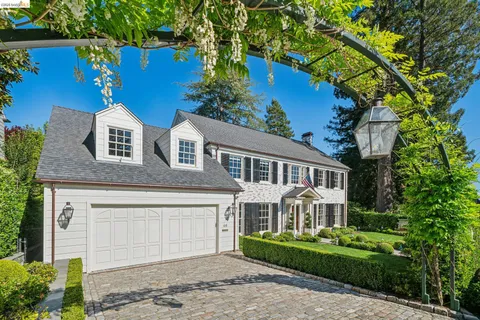 a front view of a house with a garden and plants