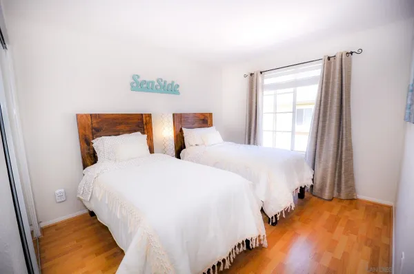 a bedroom with two beds and painting on the wall