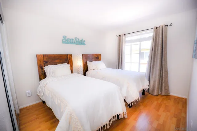 a bedroom with two beds and painting on the wall