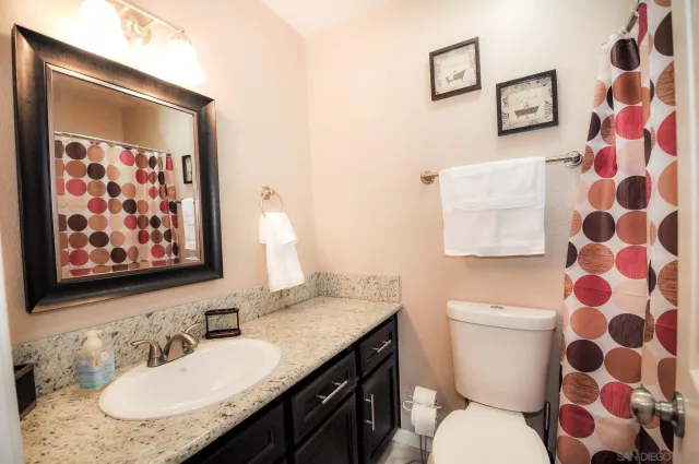 a bathroom with a granite countertop sink and a mirror