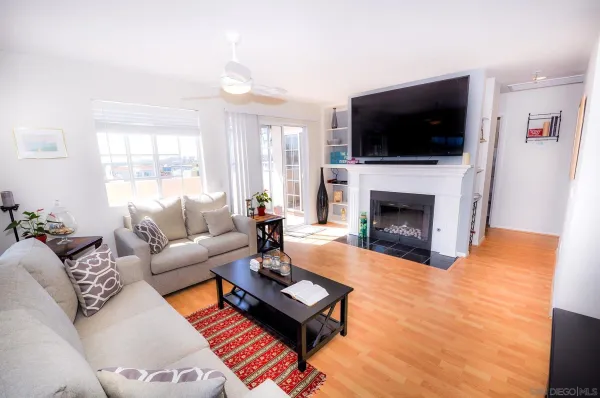 a living room with furniture a flat screen tv and a fireplace
