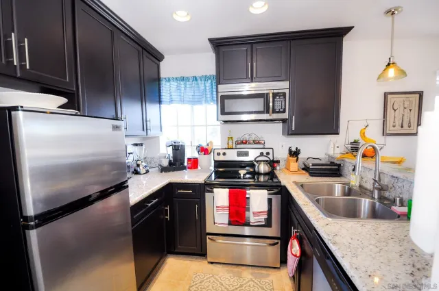 a kitchen with kitchen island granite countertop stainless steel appliances and sink