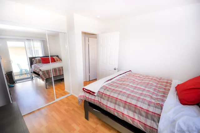 a bedroom with a bed and wooden floor