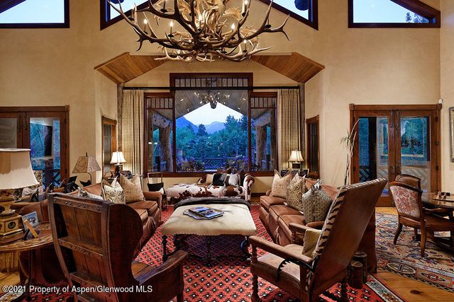 a living room with furniture a chandelier and a dining table