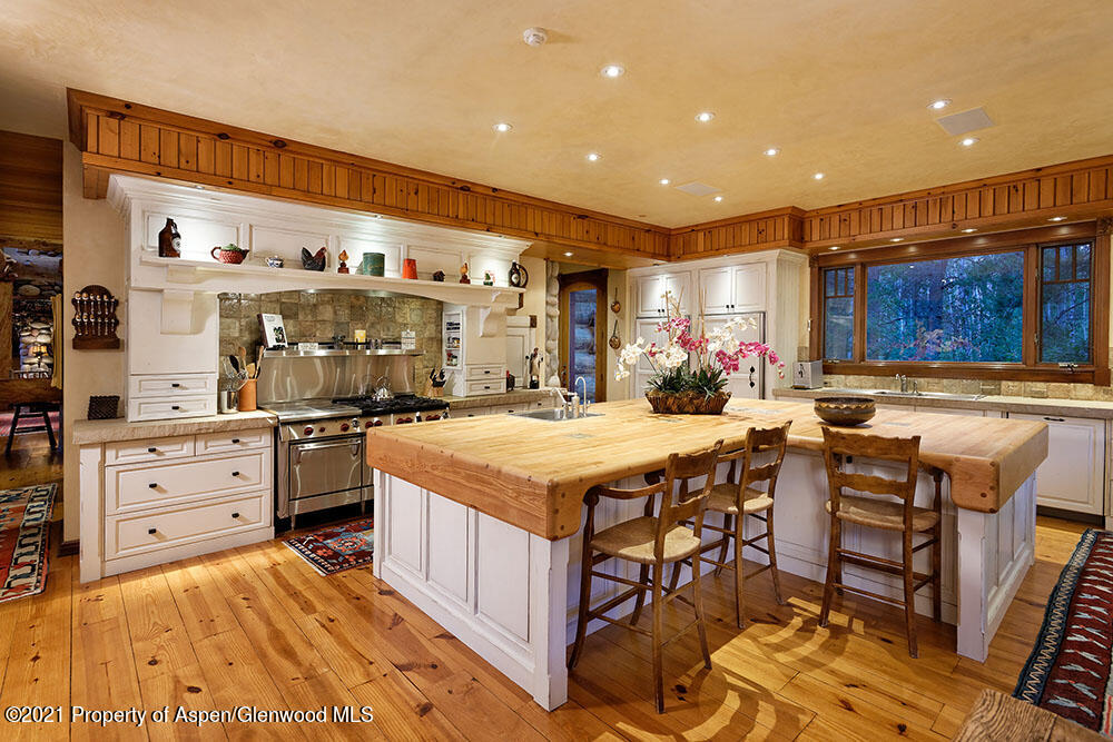 31 Northstar Circle Aspen, CO 81611 - Photo 16 of 51 a kitchen with stainless steel appliances kitchen island granite countertop a table chairs in it and wooden floors