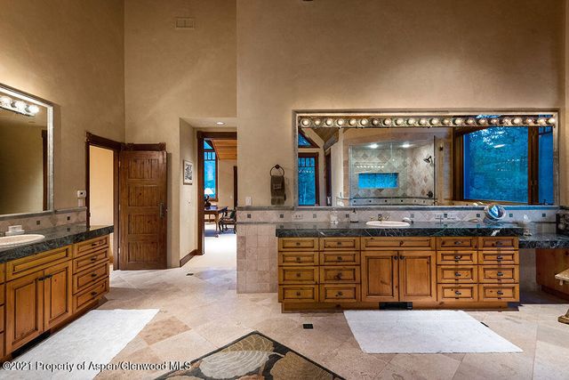 a spacious bathroom with a granite countertop sink and a mirror