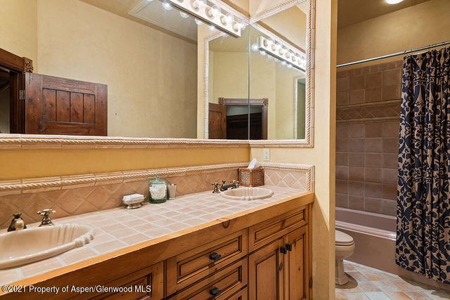 a bathroom with a granite countertop sink a mirror and shower
