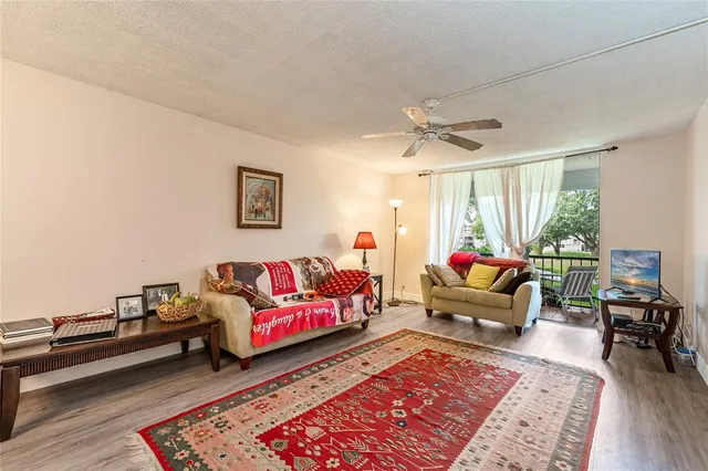 a kitchen with stainless steel appliances a refrigerator a stove a dining table and chairs with wooden floor