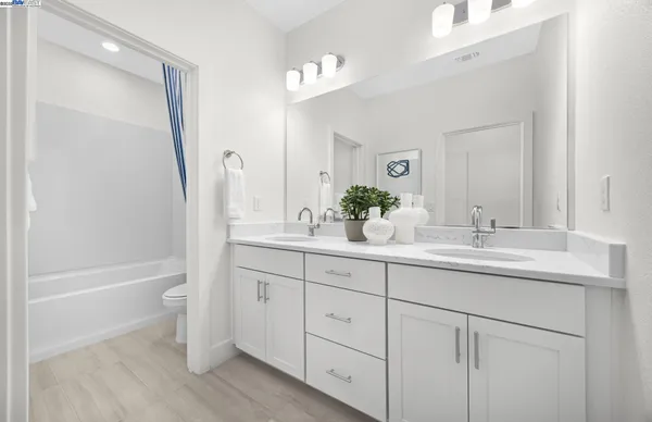 a bathroom with a tub sink and mirror