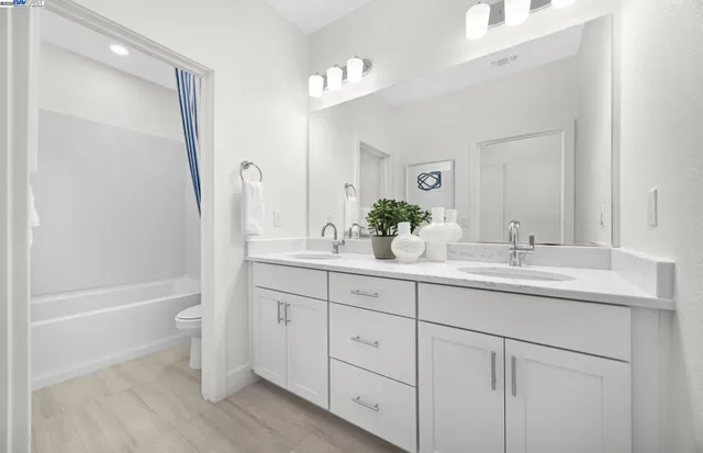 a bathroom with a tub sink and mirror