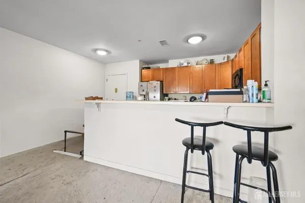 a kitchen with stainless steel appliances kitchen island a chandelier chairs and view living room
