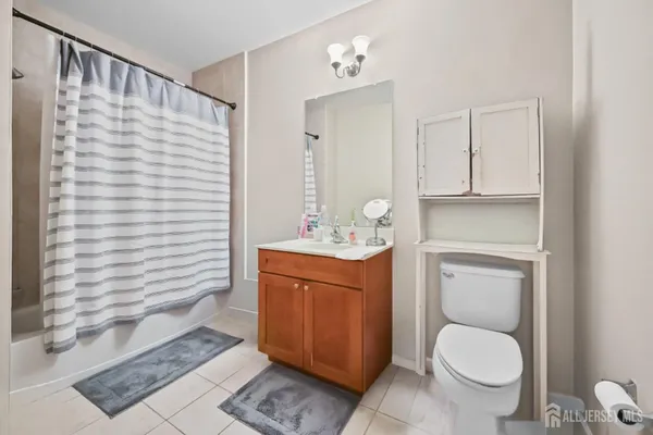 a bathroom with a granite countertop toilet sink and mirror