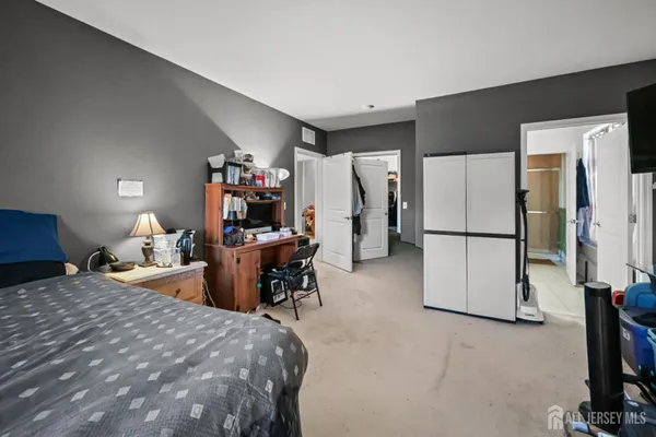 a bed room with a bed and a refrigerator