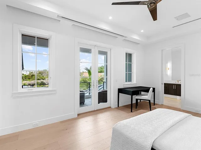 a view of swimming pool with red chairs in front of building