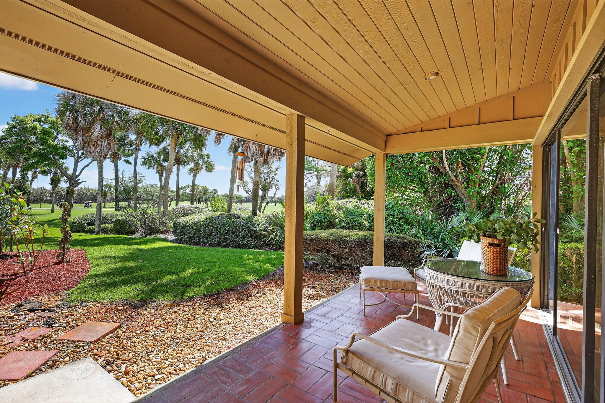 6151 Southeast Winged Foot Drive Stuart, FL 34997 - Photo 14 of 47 a view of a patio with a table chairs and a backyard