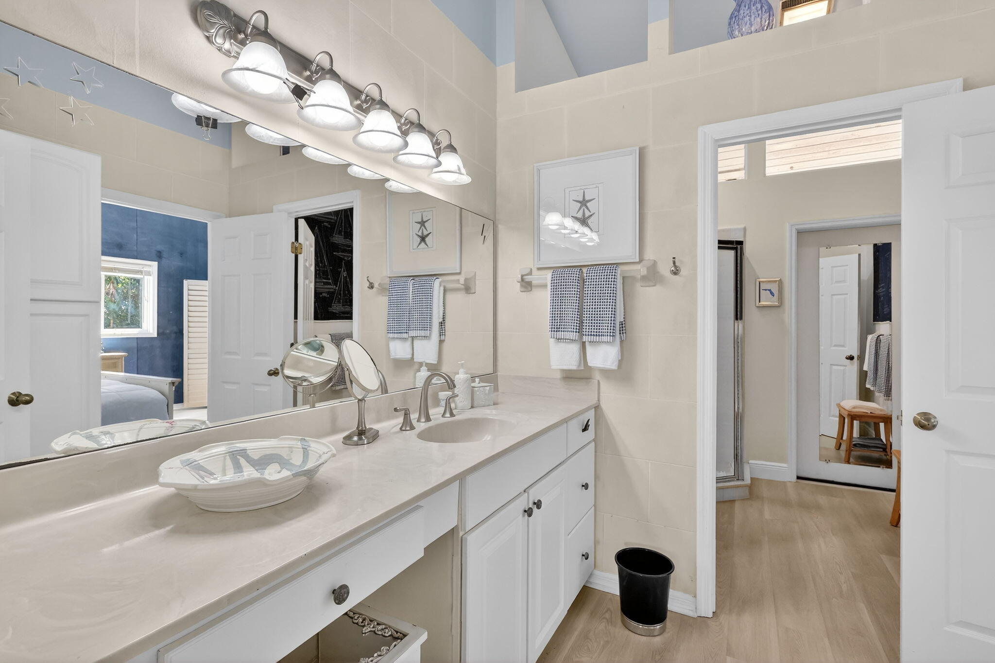 6151 Southeast Winged Foot Drive Stuart, FL 34997 - Photo 38 of 47 a bathroom with a sink a large mirror and shower