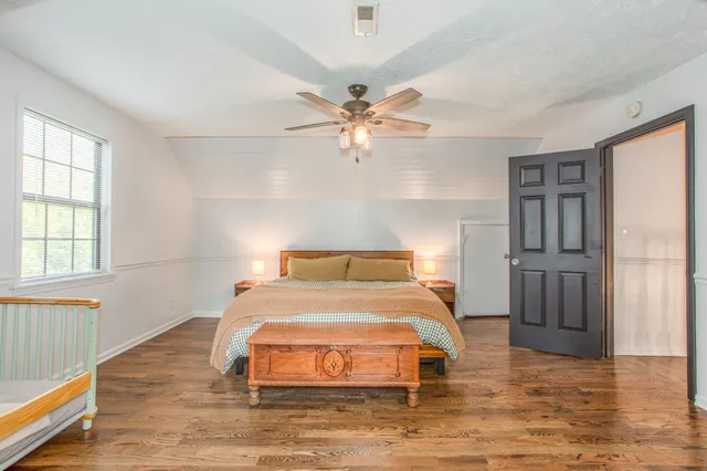 a bedroom with a bed and wooden floor
