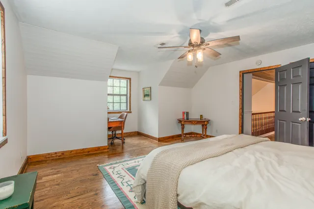a bedroom with a bed and wooden floor