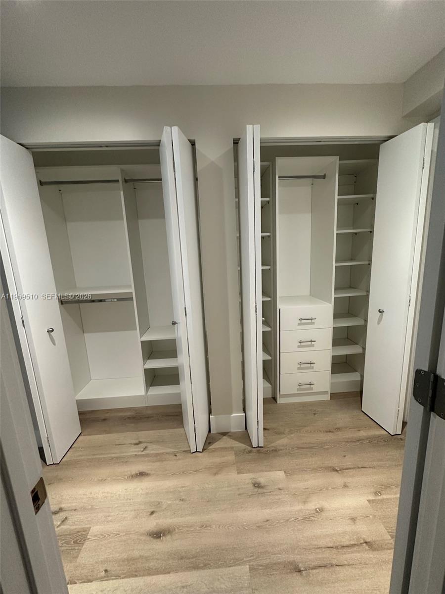801 Brickell Key Boulevard, Unit 809 Miami, FL 33131 - Photo 11 of 17 an empty room with walk in closet and wooden floor