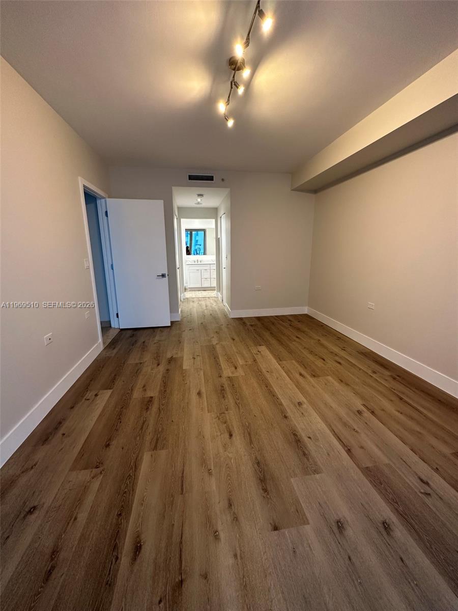 801 Brickell Key Boulevard, Unit 809 Miami, FL 33131 - Photo 5 of 17 an empty room with wooden floor and windows