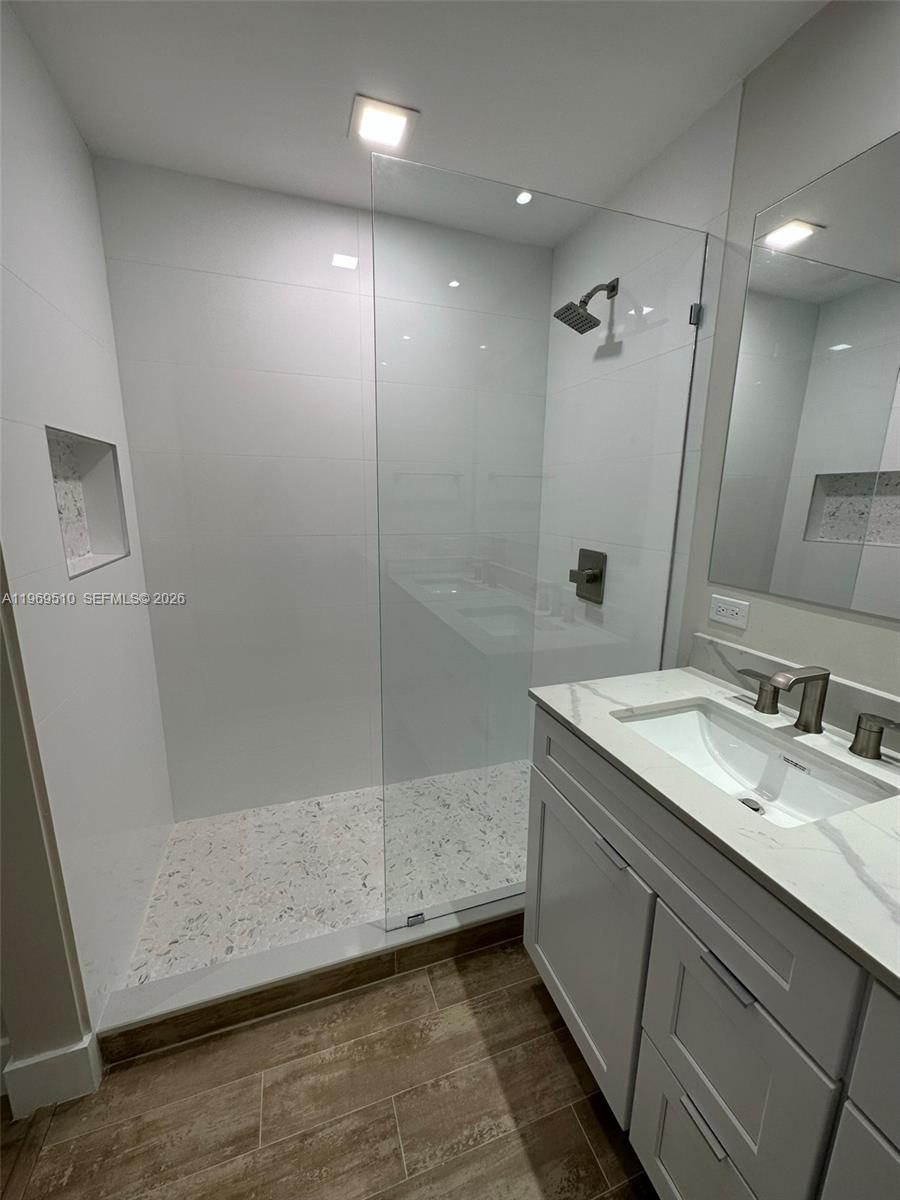 801 Brickell Key Boulevard, Unit 809 Miami, FL 33131 - Photo 7 of 17 a bathroom with a granite countertop sink a mirror and shower