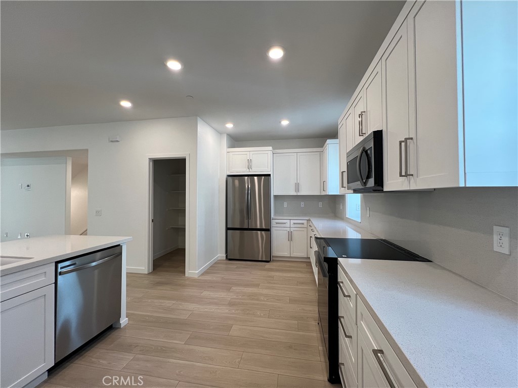 2543 Dorris Street El Monte, CA 91733 - Photo 3 of 13 a kitchen with kitchen island a sink stainless steel appliances and cabinets