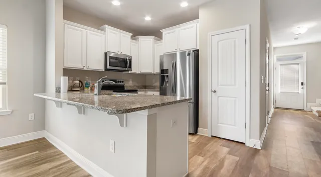 a kitchen with stainless steel appliances granite countertop a refrigerator sink and stove