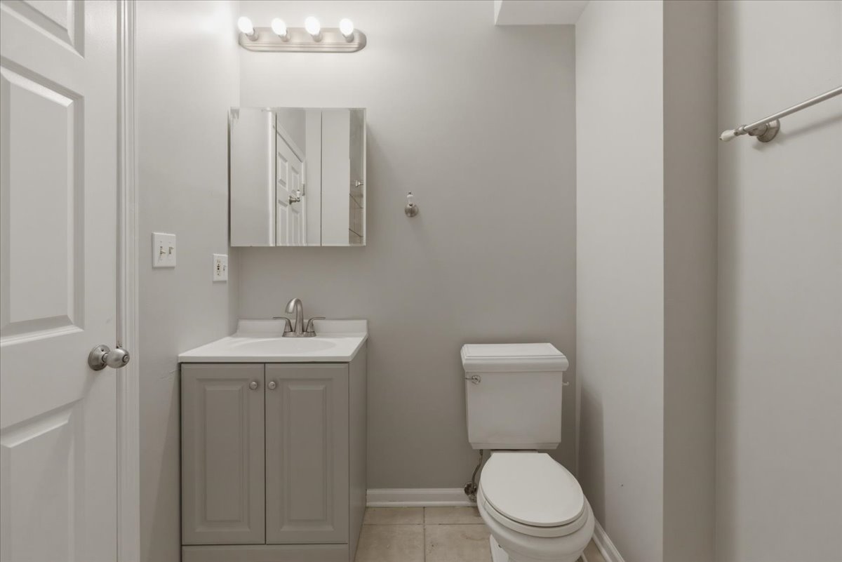 7039 West Roosevelt Road, Unit 2F Oak Park, IL 60402 - Photo 11 of 12 a bathroom with a toilet a sink and mirror