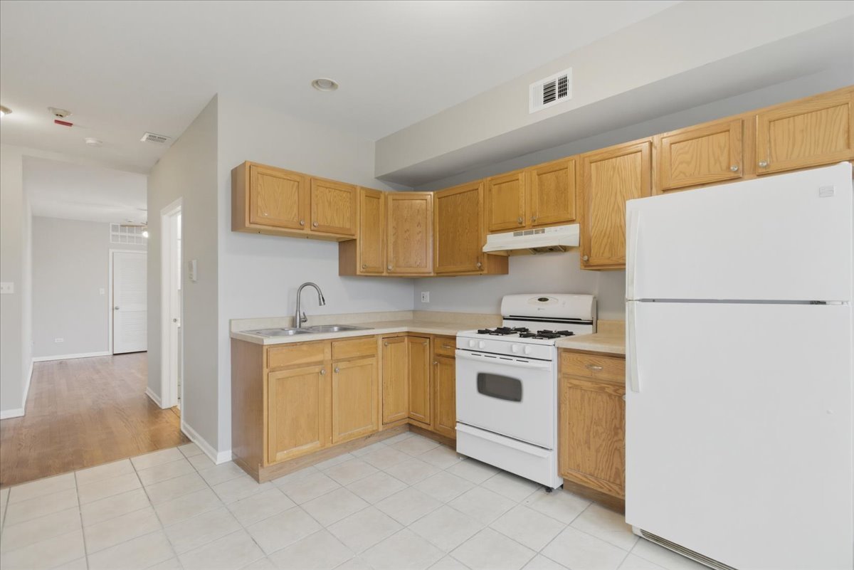 7039 West Roosevelt Road, Unit 2F Oak Park, IL 60402 - Photo 2 of 12 a kitchen with stainless steel appliances granite countertop a refrigerator sink and stove