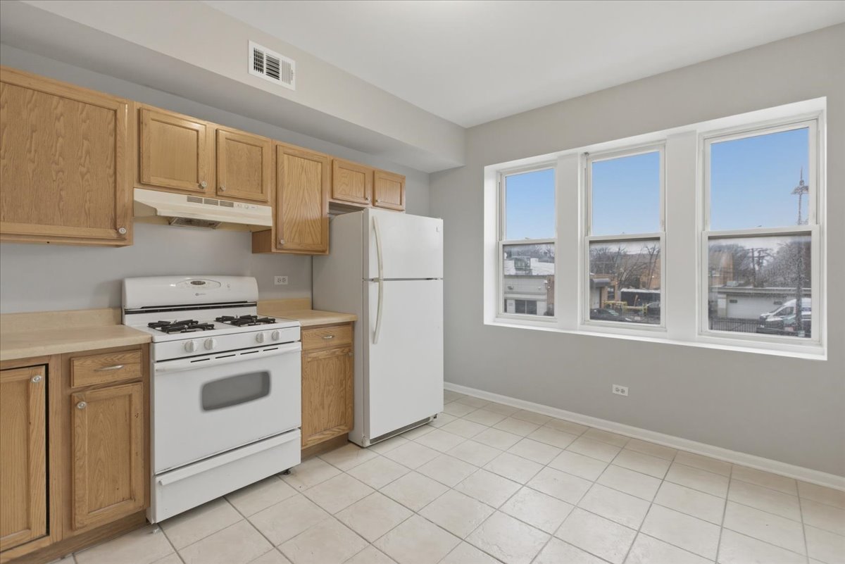 7039 West Roosevelt Road, Unit 2F Oak Park, IL 60402 - Photo 3 of 12 a kitchen with a stove a refrigerator and a sink