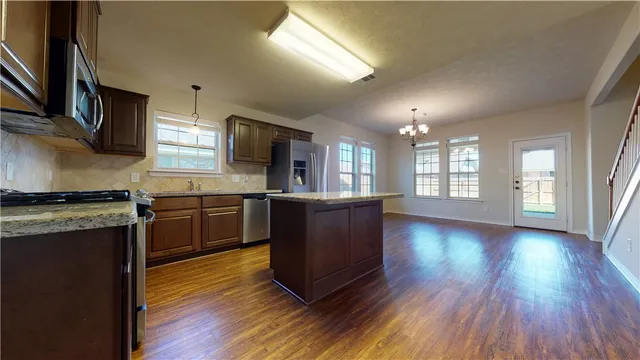 a open kitchen with a sink and a refrigerator