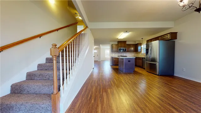 a view of a room with wooden floor staircase and a kitchen