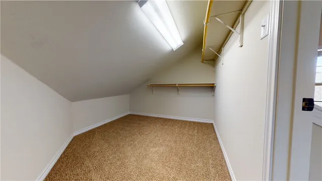 a view of an empty room and chandelier fan