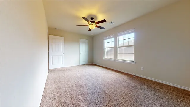 a view of an empty room with a ceiling fan