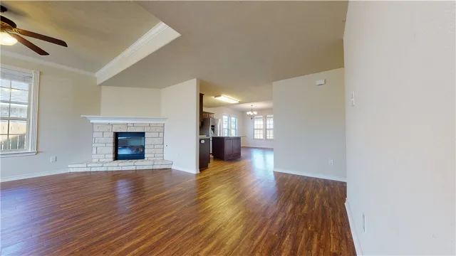 a view of a hallway with wooden floor and a fireplace