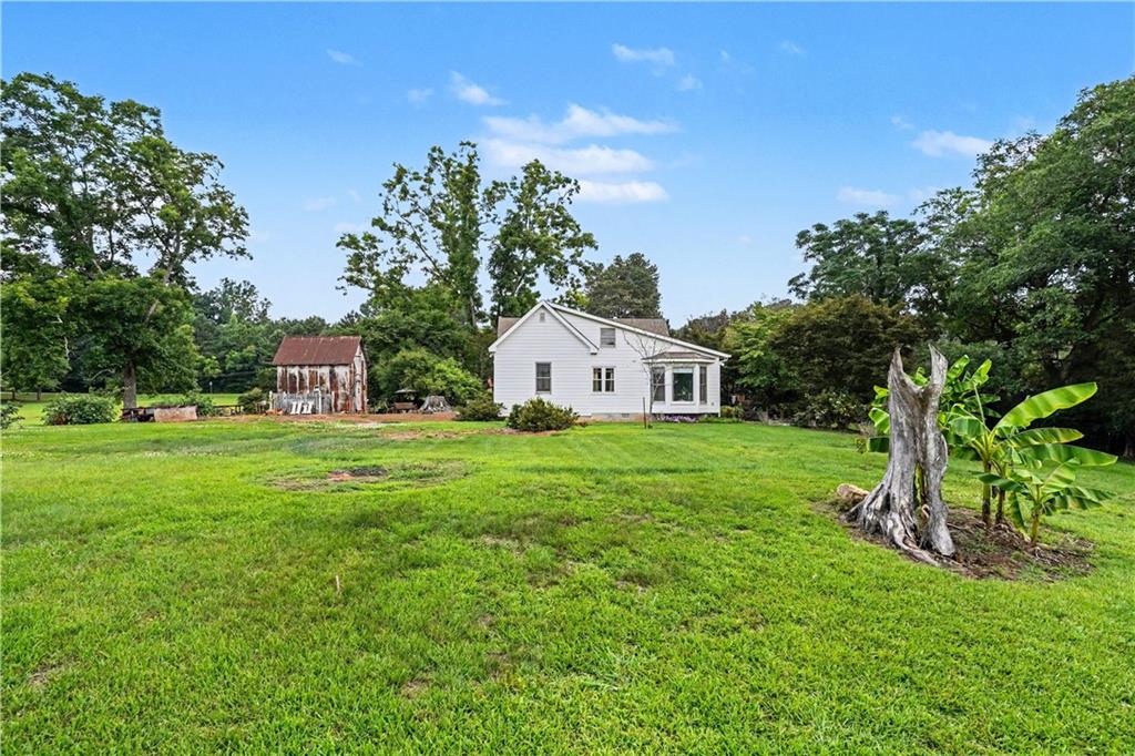 355 Inman Road Hampton, GA 30228 - Photo 34 of 47 a view of a white house in front of a big yard with large trees