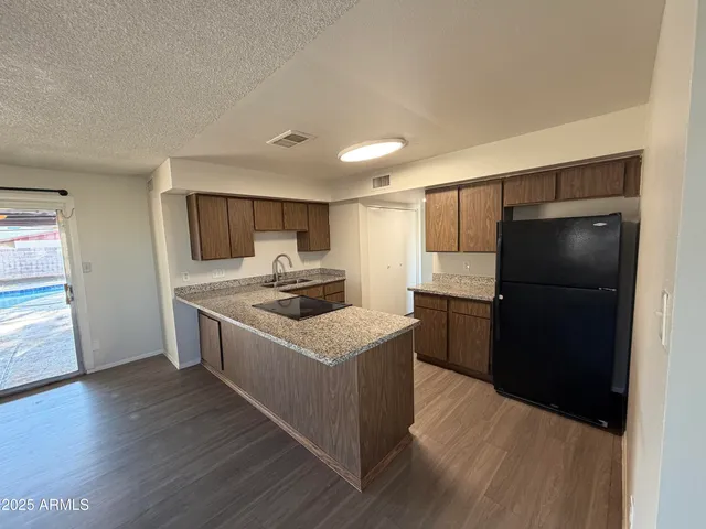 a kitchen with a refrigerator sink and cabinets