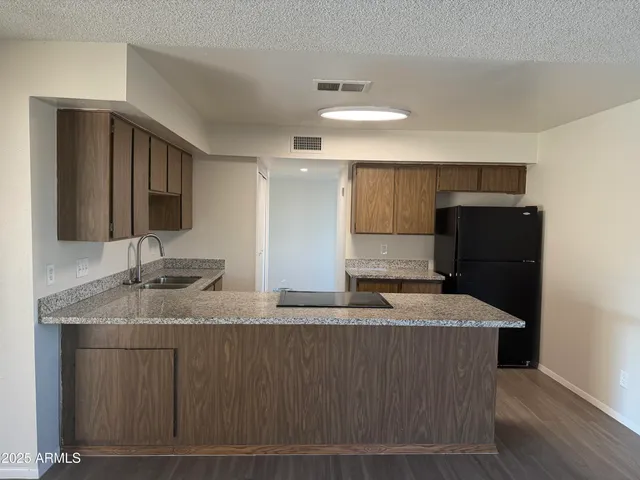 a kitchen with stainless steel appliances granite countertop a sink a refrigerator and a stove