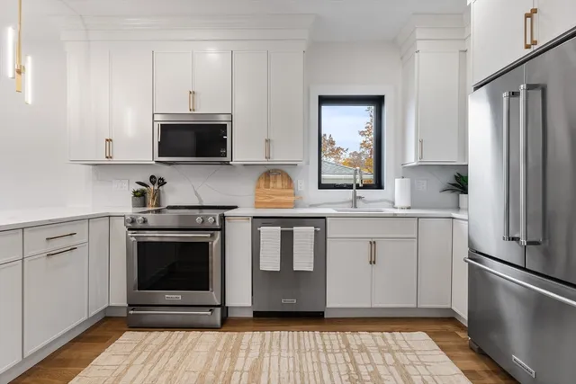 a kitchen with stainless steel appliances granite countertop a stove a sink and a refrigerator