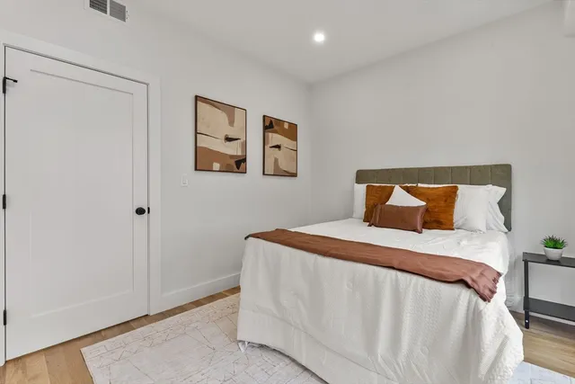 a bedroom with a bed and painting on the wall