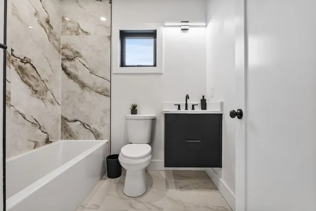 a bathroom with a sink a toilet and bathtub