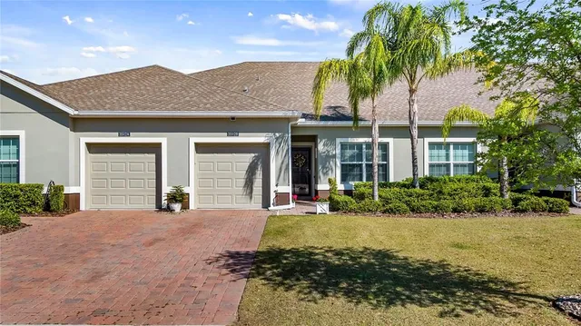 a front view of a house with a yard and potted plants