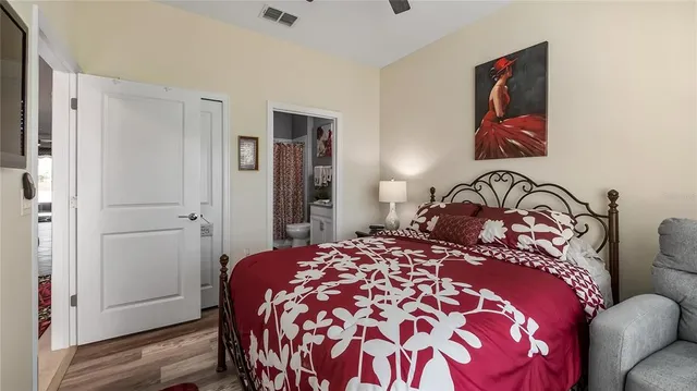 a bedroom with a large bed and a painting on the wall