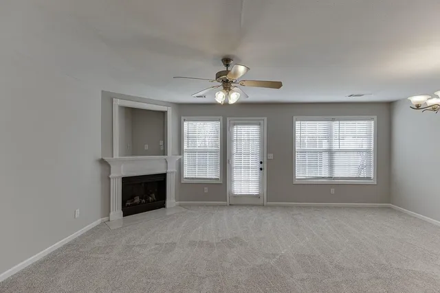 an empty room with fireplace and windows