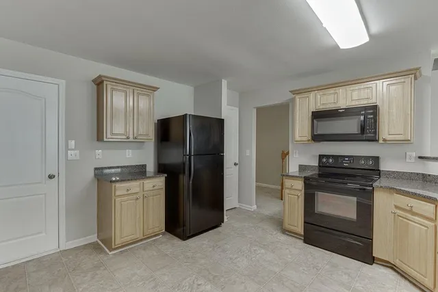 a kitchen with stainless steel appliances granite countertop a refrigerator stove and sink