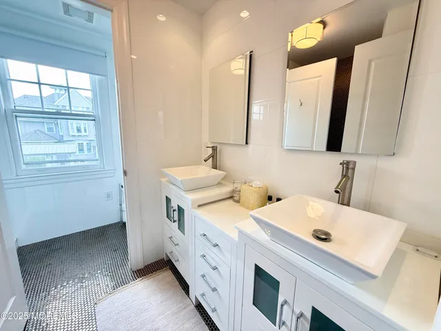 a bathroom with a double vanity sink and a mirror